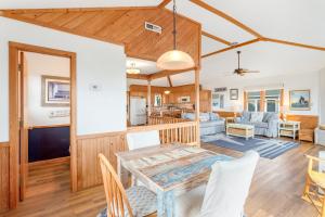 a dining room and living room with a table and chairs at 7142 - Sea 'N Sound in Nags Head