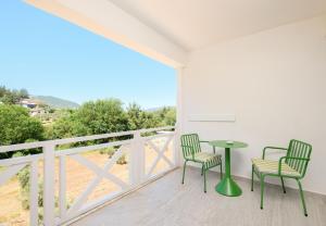 a balcony with two chairs and a table with a view at Tütsü Pension & Suites in Eskiömerler