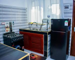 a kitchen with a sink and a stove and a refrigerator at Salsa Holiday apartments in Diani Beach