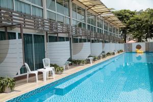 a swimming pool with chairs and a building at Full Stop Pool Villa Don Mueang in Lak Si