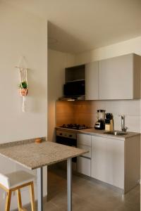 a kitchen with white cabinets and a counter top at Modern apartment with direct ocean view in Simón Bolivar