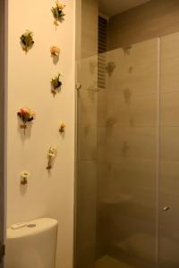a bathroom with a toilet and flowers on the wall at Modern apartment with direct ocean view in Simón Bolivar +25 photos