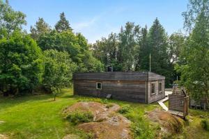 a cabin in the middle of a field with trees at Embrace The Island Life And Natural Wilderness in Vätö