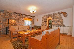 a living room with a table and a stone wall at Erika in Šumber (Haus für 4-6 Personen) in Nedeščina