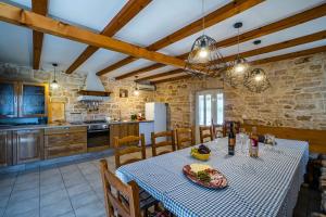 une cuisine et une salle à manger avec une table et des chaises dans l'établissement Kutić in Štokovci (Haus für 10-15 Personen), à Svetvinčenat