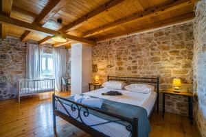 une chambre avec un lit et un mur en pierre dans l'établissement Kutić in Štokovci (Haus für 10-15 Personen), à Svetvinčenat 36 autres photos