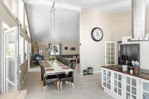 eine Küche und ein Esszimmer mit einem Tisch und einer Uhr in der Unterkunft 3716 Nexø - Granvej 12 in Snogebæk + 12 Fotos