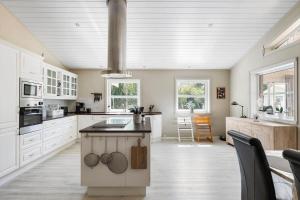 eine große Küche mit weißen Schränken und einer großen Insel in der Unterkunft 3716 Nexø - Granvej 12 in Snogebæk