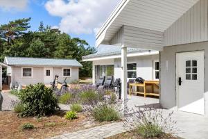 ein Haus mit einer Terrasse mit Tisch und Stühlen in der Unterkunft 3716 Nexø - Granvej 12 in Snogebæk