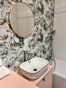 a bathroom with a sink and a mirror at Zoo Arena Stay Free Parking in Łódź +14 photos