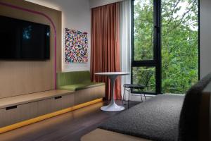 a living room with a tv and a window at The Artful Way Hotel in Asheville