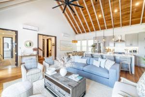 Cayo RomeroにあるThe Palms and The Pool Club at Mahogany Bayの青いソファとキッチンのあるリビングルーム