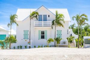 Cayo RomeroにあるThe Palms and The Pool Club at Mahogany Bayのヤシの木が目の前に広がる白い家