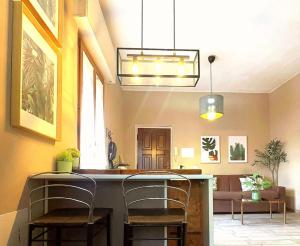 a kitchen with two chairs and a bar in a room at APPARTAMENTO CREMONA FIERA in Cremona