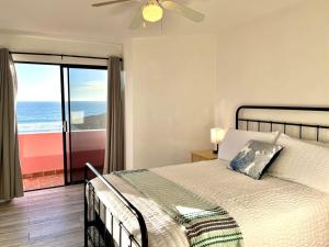 a bedroom with a bed with a view of the ocean at Oceanfront - Casita Rosa in Puerto Nuevo