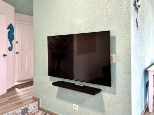 a flat screen tv on a green wall at Oceanfront - Casita Rosa in Puerto Nuevo