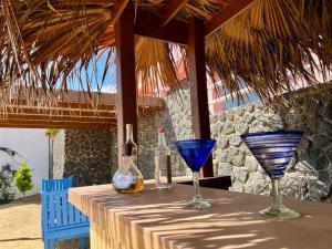 a table with wine bottles and glasses on it at Oceanfront - Casita Rosa in Puerto Nuevo