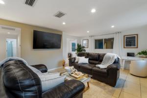 a living room with leather furniture and a flat screen tv at St Petersburg Private Villa with Pool Gym Grill Self Check-In in St Petersburg