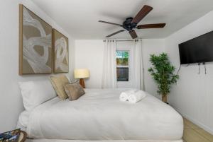 a bedroom with a white bed with a ceiling fan at St Petersburg Private Villa with Pool Gym Grill Self Check-In in St Petersburg