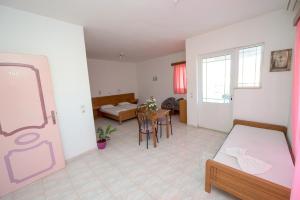a room with two beds and a dining room at Old Windmill Studios in Faliraki