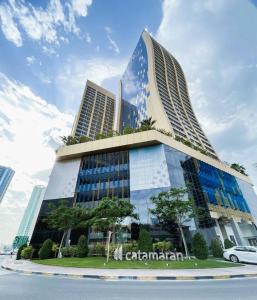a tall building with a car parked in front of it at Hive Stayz - 1 Bedroom in Catamaran Tower in Sanābis