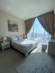 a bedroom with a bed and a large window at Hive Stayz - 1 Bedroom in Catamaran Tower in Sanābis