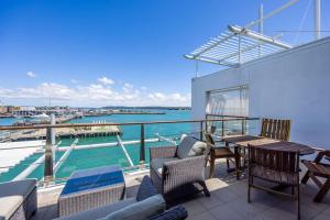 a balcony with furniture and a view of the water at QV Stays Waterfront Elegance on Princes Wharf in Auckland