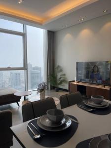 a living room with a table and chairs and a television at Hive Stayz - 1 Bedroom in Catamaran Tower in Sanābis