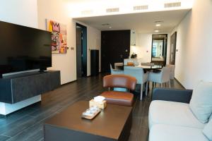 a living room with a couch and a tv and a table at Hive Stayz - 1 Bedroom Canal Harbor Row in Manama