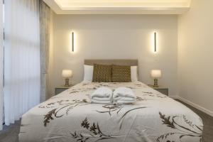 a bedroom with a bed with two towels on it at Lake Haven apartment 1 - fabulous location near lake and town in Taupo