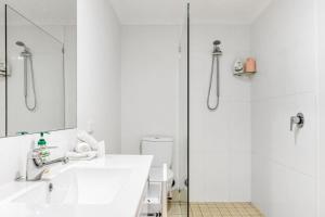 een witte badkamer met een wastafel en een douche bij Sandy Bottoms in Brunswick Heads +13 foto's