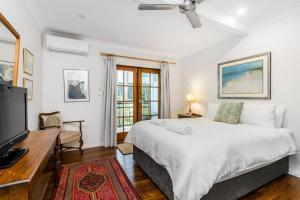 een slaapkamer met een bed en een flatscreen-tv bij Sandy Bottoms in Brunswick Heads