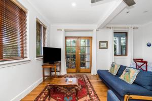 een woonkamer met een blauwe bank en een tv bij Sandy Bottoms in Brunswick Heads