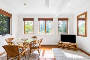 une salle à manger avec une table et des chaises et une télévision dans l'établissement Lil Nauti, à Brunswick Heads