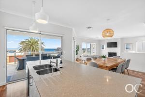 a kitchen and dining room with a view of the ocean at Boomer View in Port Elliot
