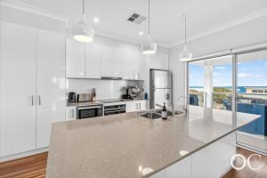 a kitchen with white cabinets and a counter top at Boomer View in Port Elliot
