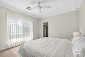 a white bedroom with a bed and a ceiling fan at Boomer View in Port Elliot +31 photos