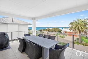 a table and chairs on a balcony with a view of the ocean at Boomer View in Port Elliot