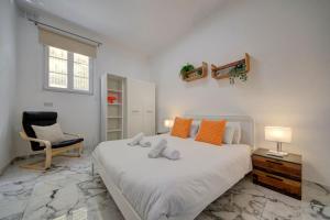 a bedroom with a large white bed and a chair at Casa Elena, Private Garden, Office,1 Minute to the Sea by Haven & Keys Malta in Sliema +29 photos