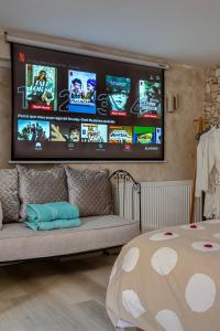 TV a/nebo společenská místnost v ubytování L'Escapade Enchantée - Spa, Cheminée et Cinéma