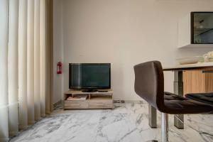 a living room with a television and a chair at Casa Elena, Private Garden, Office,1 Minute to the Sea by Haven & Keys Malta in Sliema
