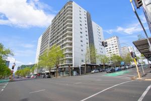 a tall white building on a city street at City Vista Apt with Views - Pool and Gym in Auckland