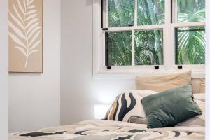 una camera con un letto con una finestra e un cuscino di Broadviews Secret Hideaway a Brunswick Heads