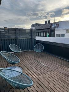 zwei blaue Stühle auf einem Holzdeck in der Unterkunft City center apartment with sauna & rooftop terrace in Pori
