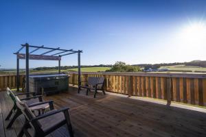 una terraza con 2 sillas y una parrilla en la cubierta en Crofthead Holiday Park, en Ayr