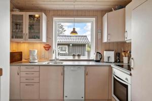 een keuken met een spoelbak en een raam bij LN2032-Hjorring-Krattet-9 in Lønstrup +14 foto's