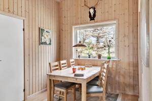 een eetkamer met een tafel en stoelen en een raam bij LN2032-Hjorring-Krattet-9 in Lønstrup