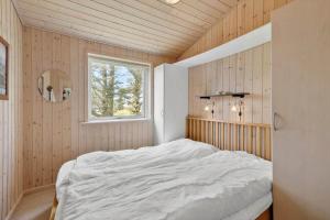 een slaapkamer met een bed in een kamer met een raam bij LN2032-Hjorring-Krattet-9 in Lønstrup