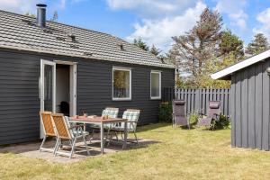 een terras met een tafel en stoelen voor een huis bij LN2032-Hjorring-Krattet-9 in Lønstrup