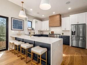 a kitchen with a large island with bar stools at High End New Build, Rooftop Hot Tub, City Views in Milo